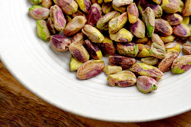 istock Shelled roasted pistachio nuts in plate on wooden table 2216382669