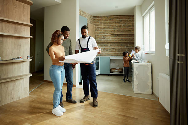 istock Black parents and manual worker analyzing blueprints in the apartment. 2216386687