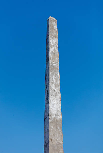istock A tall, gray pillar stands in front of a clear blue sky 2216388911