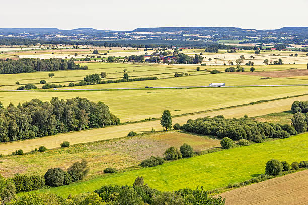 istock Patchwork landscape with traffic on a country road in the summer 2216390254