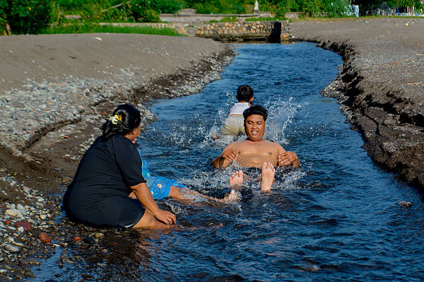istock Children walking in shallow stream by the beach 2216390608