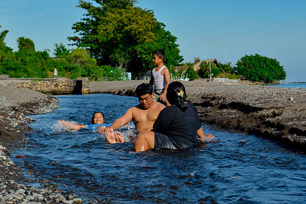 A calm yet playful family moment near the flowing water