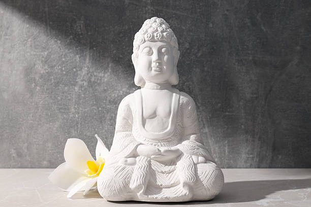 istock Buddha statue and flower on gray background 2216391387