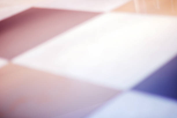 A blurred image capturing a checkered floor with a prominent white square at its center, showcasing an array of colors like violet, magenta, carmine, peach, and electric blue