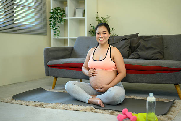 istock Happy pregnant woman relaxing on a mat during her home workout routine 2216392975