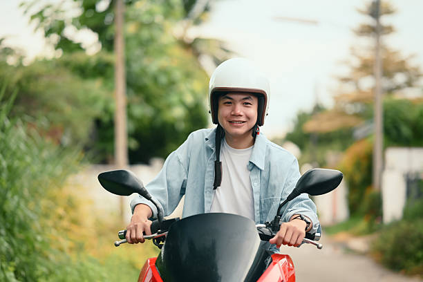 istock Cheerful young man wearing helmet riding  motorcycle 2216394817