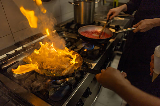 istock Chef and sous-chef cooking with fire in commercial kitchen 2216396008