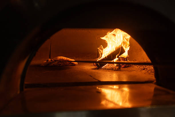 istock Delicious pizza baking in a traditional wood-fired oven 2216396640