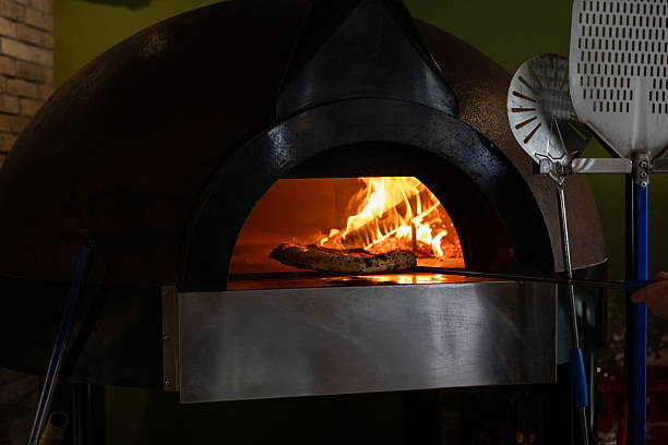 istock Delicious pizza baking in a traditional wood-fired oven 2216396654