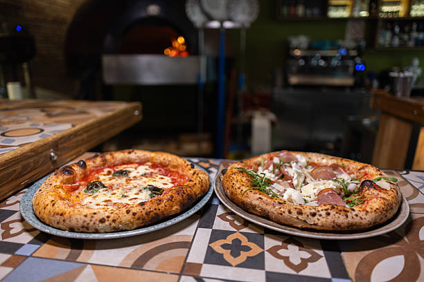 istock Freshly prepared pizzas in restaurant kitchen 2216396782