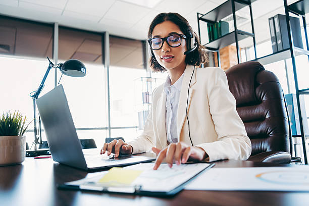 istock Professional businesswoman in elegant attire working at her office desk, utilizing technology for efficient communication 2216397372