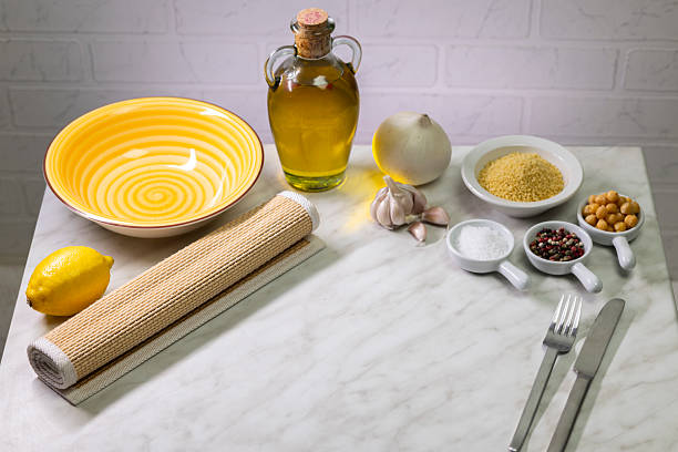 Ingredients for preparing vegetarian couscous with chickpeas, lemon, garlic and onion on marble table
