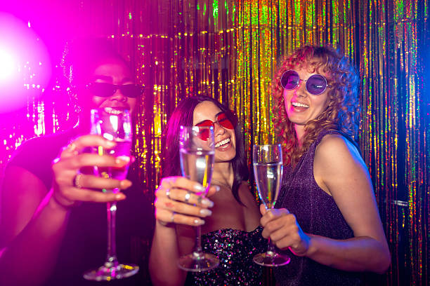 istock Cheerful multi-ethnic girlfriends toasting with champagne flutes at disco party 2216403862