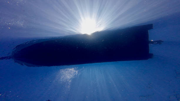 istock View from below of a motorboat and sun rays from underwater. 2216404303
