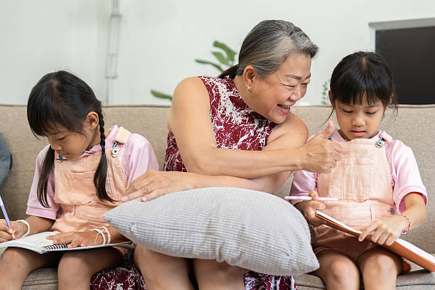 istock Learning and Bonding. A grandmother engages with her granddaughters as they work on their school activities. 2216405556
