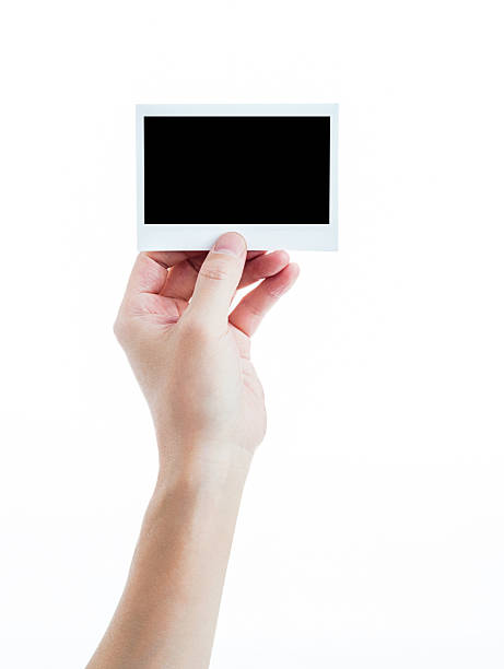 istock Human hand holding blank instant photo card on white background 2216406124