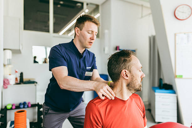 A physiotherapist performs a therapeutic neck treatment on a client in a professional clinic environment. The scene conveys professionalism, care, and the focus on health and well-being.