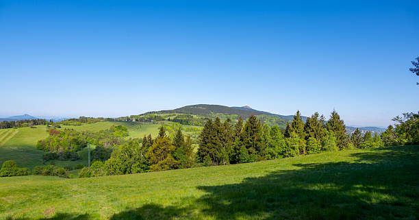 istock Panoramic view of Jested mountain with its iconic tower on the top, surrounded by green meadows, scattered cottages and small villages in the Czech countryside 2216408457