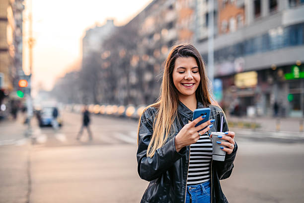 istock Young Woman Texting On The Phone While Drinking A Milkshake In The City 2216409593