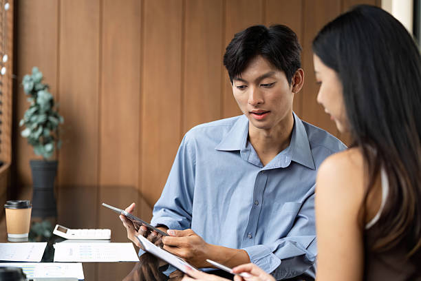 istock Business Collaboration. Young professionals analyzing data together in a stylish office. 2216411656