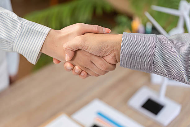 istock ESG Partnership Agreement. Business professionals shaking hands in an office setting. 2216413899