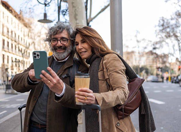 istock Senior tourists using smartphone and drinking coffee in barcelona 2216417826
