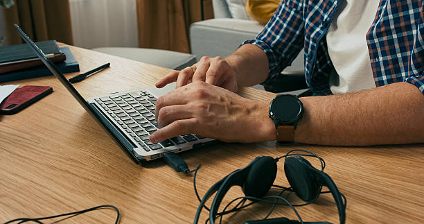 istock Close up shot selective focus on man's hands typing on keyboards. Beard man works online from home concentrated serious . 2216419231