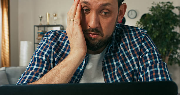 istock A bearded man in deep thought takes a phone call while working from home, showing confusion and dissatisfaction while discussing unresolved tasks for a new online project. 2216419563