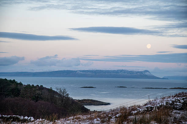 The Morar Peninsula is part of the area of the Scottish Highlands known as the Rough Bounds.  This area is remote and sparsely populated.  View from Arisaig over the sea to the Isle of Eigg.  Photo taken in winter, February, an hour before sunset