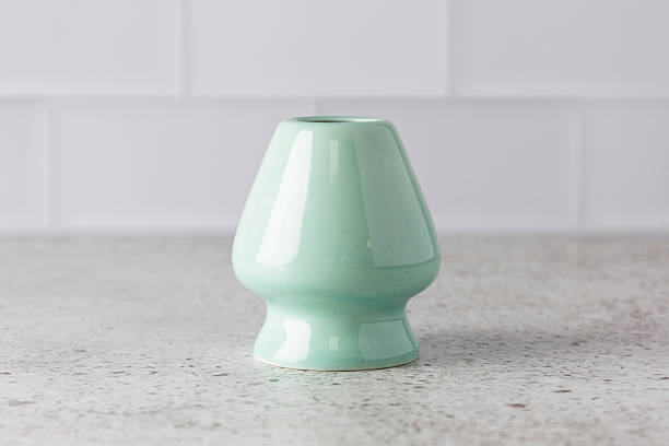 Light green ceramic matcha whisk holder standing on kitchen countertop