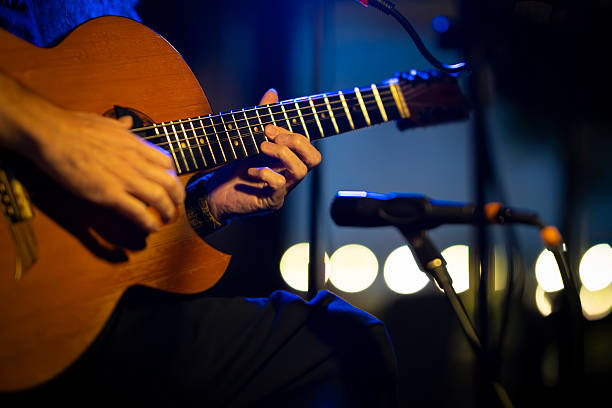 istock Musician playing acoustic guitar on stage during live performance 2216425577