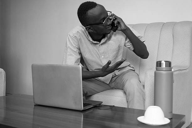 istock Focused Young Man Discussing Business on Mobile Phone in Home Office 2216426062