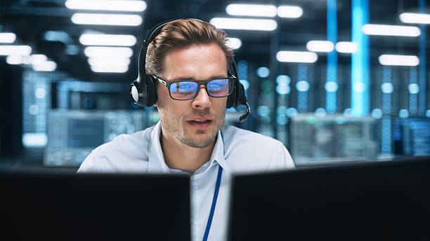 istock Customer Service Operator at Work in Call Center. Caucasian Call Center Worker Talking with Customer in Modern Office at Night. Worker Speaking on Video Call on Computer Sitting at Table at Office 2216426507