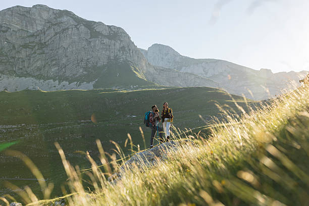 istock Hikers standing on mountain ridge enjoying scenic view 2216429101