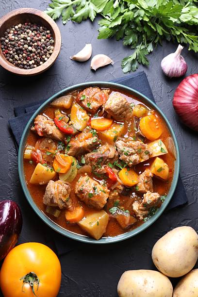 istock Delicious stew and different ingredients on black table, flat lay 2216468162
