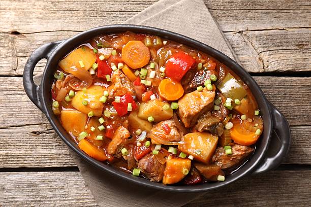 istock Delicious stew with vegetables in baking dish on wooden table, top view 2216469355