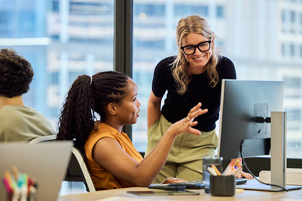 istock Manager leaning at desk and discussing with colleague 2216469510