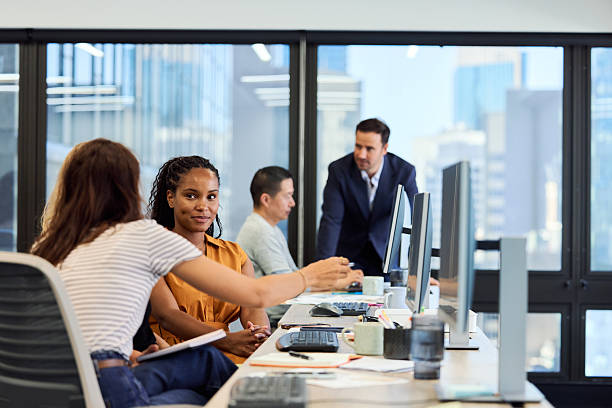 istock Businesswomen discussing ideas while sitting at desk 2216470019
