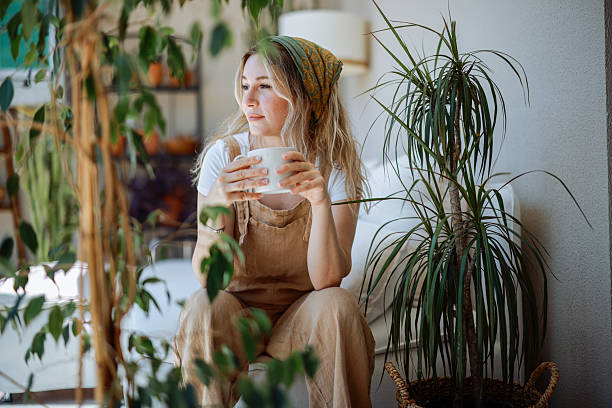 istock Woman holding coffee cup while looking away at home 2216470061