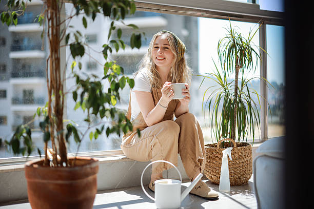 istock Woman holding coffee cup while looking away at home 2216470215