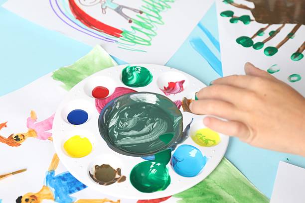 istock Boy drawing picture with paint at light blue table, closeup 2216470475