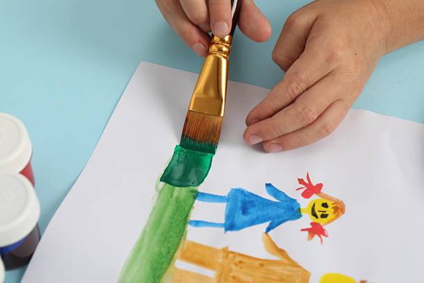 istock Boy drawing picture with paint at light blue table, closeup 2216470478