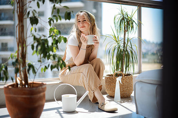 istock Woman holding coffee cup while looking away at home 2216473743