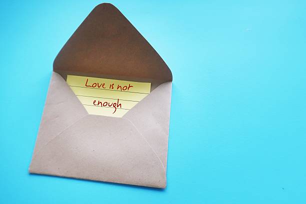 istock On blue copy space background, envelope with card written LOVE IS NOT ENOUGH - means healthy relationships require more than pure love or passions  - it demands respect, communication and commitment 2216474087
