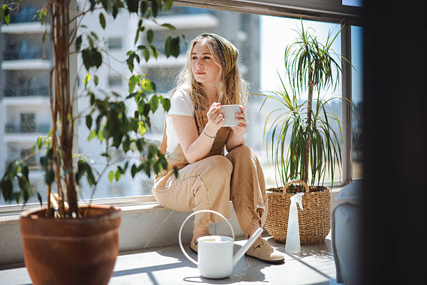 istock Woman holding coffee cup while looking away at home 2216474174