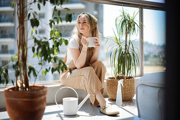 istock Woman holding coffee cup while looking away at home 2216477807