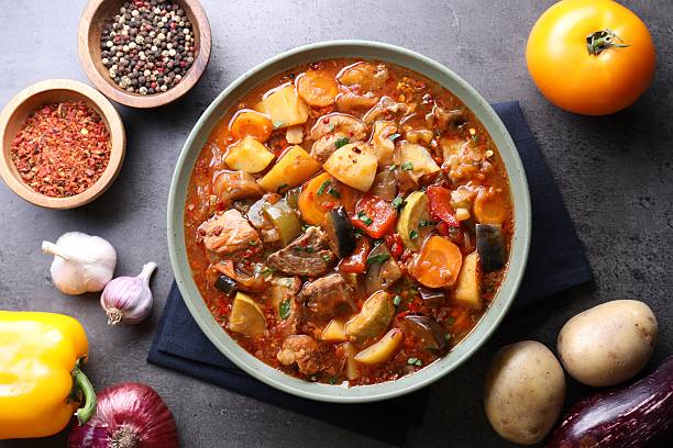 istock Delicious stew with vegetables in bowl and ingredients on grey table, flat lay 2216478223