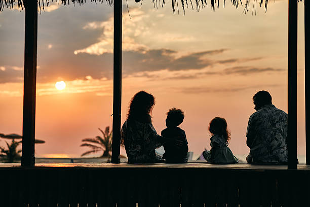 A family enjoying a tropical paradise beach during sunset.