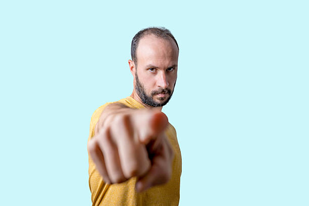 young man pointing finger at camera with serious confident expression