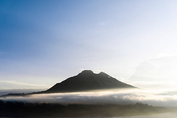 Majestic mountain peak emerges from a sea of clouds.